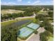 Aerial shot highlighting well-maintained tennis courts with fresh green surfaces and a neatly organized parking area at 5138 Rishley Run Way, Mount Dora, FL 32757