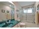 Bathroom featuring a green countertop, shower, and large mirror at 5408 Queen Victoria Dr, Leesburg, FL 34748