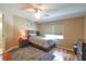 Neutral bedroom with wood floors, ceiling fan, and bedside table at 5408 Queen Victoria Dr, Leesburg, FL 34748