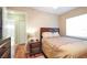Well-lit bedroom with wood flooring, and connecting bathroom at 5408 Queen Victoria Dr, Leesburg, FL 34748