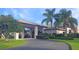 A beautiful clubhouse with lush landscaping, an arched entrance, and a paved driveway at 5408 Queen Victoria Dr, Leesburg, FL 34748