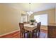 Cozy dining room with a view of the front door; hardwood floors and a chandelier at 5408 Queen Victoria Dr, Leesburg, FL 34748