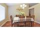 Inviting dining room featuring hardwood floors, a chandelier, and large window at 5408 Queen Victoria Dr, Leesburg, FL 34748
