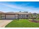 Charming single-story home featuring a well-maintained lawn and an attached two-car garage at 5408 Queen Victoria Dr, Leesburg, FL 34748