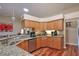 Functional kitchen with granite countertops, stainless steel appliances, and wood cabinetry at 5408 Queen Victoria Dr, Leesburg, FL 34748