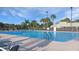 A large community pool on a sunny day with palm trees and seating at 5408 Queen Victoria Dr, Leesburg, FL 34748