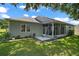 Backyard view with a patio, landscaped yard, and screened lanai at 5557 Freeport Dr, Tavares, FL 32778