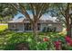 Large backyard with mature trees, landscaping, and a screened lanai at 5557 Freeport Dr, Tavares, FL 32778