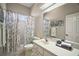 Bathroom with a floral shower curtain, a vanity with lots of counter space and a large mirror at 5557 Freeport Dr, Tavares, FL 32778