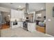 Modern kitchen with stainless steel appliances, granite countertops, white cabinets, and an open layout to the living area at 5557 Freeport Dr, Tavares, FL 32778