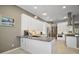 Updated kitchen with stainless steel appliances, granite countertops, white cabinets, and modern lighting at 5557 Freeport Dr, Tavares, FL 32778