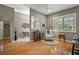 Bright open floor plan featuring hardwood floors, a ceiling fan, and large windows for natural light at 5557 Freeport Dr, Tavares, FL 32778