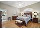 Serene main bedroom with hardwood floors, a ceiling fan, and access to the bathroom at 5557 Freeport Dr, Tavares, FL 32778