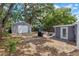 Large backyard with mature trees, detached garage, and grill area at 602 Ross St, Leesburg, FL 34748
