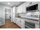 Modern kitchen with stainless steel appliances and sleek white cabinetry at 602 Ross St, Leesburg, FL 34748