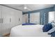 Bright main bedroom features calming blue accent wall, ample closet space, and ceiling fan at 602 Ross St, Leesburg, FL 34748