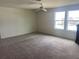 Spacious bedroom featuring neutral carpeting, a ceiling fan, and bright windows at 709 Sarner Pass Way, Winter Haven, FL 33881