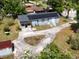 Aerial view of a home featuring a solar panel roof, a large driveway, and mature trees at 726 S Stone St, Deland, FL 32720