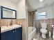 Bathroom featuring blue vanity, tub with shower, and wood-look ceramic tiled walls at 726 S Stone St, Deland, FL 32720