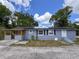 Charming single-story home with a light grey exterior, solar panels and a welcoming, covered front porch at 726 S Stone St, Deland, FL 32720