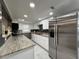 Modern kitchen featuring stainless steel appliances, granite countertops, white cabinets and stylish backsplash at 726 S Stone St, Deland, FL 32720