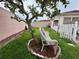 Private backyard with a tranquil seating area beneath a lush tree offering shade and relaxation at 728 Ramirez Ave, The Villages, FL 32159