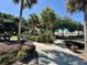 Scenic community landscape featuring lush landscaping, winding walking paths, and mature trees under a bright blue sky at 728 Ramirez Ave, The Villages, FL 32159