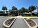 Community entrance with a gated walkway, lush landscaping, and beautiful rocks in a suburban neighborhood at 728 Ramirez Ave, The Villages, FL 32159