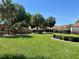 Well-maintained green space with manicured lawns, mature trees, and lush landscaping in a residential community at 728 Ramirez Ave, The Villages, FL 32159