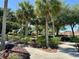 Scenic community landscape featuring lush landscaping, walking paths, and mature trees under a bright blue sky at 728 Ramirez Ave, The Villages, FL 32159