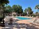Community pool featuring lounge chairs, shaded seating, clear water, and beautiful landscaping at 728 Ramirez Ave, The Villages, FL 32159