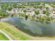 Aerial view showcasing the community, a tranquil lake, lush landscaping, and a nearby golf course at 8043 Pine Hollow Dr, Mount Dora, FL 32757