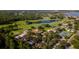 Aerial view of the neighborhood with a golf course, lake, clubhouse, tennis courts, and residences at 8043 Pine Hollow Dr, Mount Dora, FL 32757