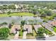 Aerial shot showcasing the property's location on the water, adjacent to a golf course, within a charming community at 8043 Pine Hollow Dr, Mount Dora, FL 32757