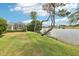 Expansive backyard featuring a scenic waterfront view and lush green lawn leading to the lake at 8043 Pine Hollow Dr, Mount Dora, FL 32757