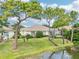 The backyard features mature trees, lush green grass, and views of the lake at 8043 Pine Hollow Dr, Mount Dora, FL 32757