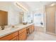 Bright bathroom offers double sinks, shower, tub, and white tile floors at 8043 Pine Hollow Dr, Mount Dora, FL 32757