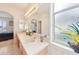 Open bathroom showcases a large mirror, a double-sink vanity, and bright lighting fixtures at 8043 Pine Hollow Dr, Mount Dora, FL 32757