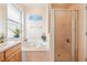 Bathroom boasting large tub, glass shower and a window with natural light at 8043 Pine Hollow Dr, Mount Dora, FL 32757