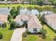 A charming single-story home boasts lush landscaping and a serene lake view with golf course backdrop at 8043 Pine Hollow Dr, Mount Dora, FL 32757