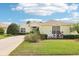 Charming single-story home with manicured landscaping, a well-maintained lawn, and a welcoming driveway at 8043 Pine Hollow Dr, Mount Dora, FL 32757