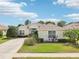 Inviting single-Gathering home featuring a well-maintained lawn, mature landscaping, and a paved driveway at 8043 Pine Hollow Dr, Mount Dora, FL 32757