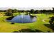 Aerial view of the golf course with water feature, sand traps and immaculate landscaping at 8043 Pine Hollow Dr, Mount Dora, FL 32757