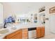 Kitchen features white countertops, double sink, wooden cabinets, and view of the living room at 8043 Pine Hollow Dr, Mount Dora, FL 32757