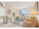 Comfortable living room features a floral sofa set, decorative lamps, and a view of the lake at 8043 Pine Hollow Dr, Mount Dora, FL 32757