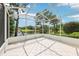 Screened-in patio overlooking lush greenery and a serene lake at 8043 Pine Hollow Dr, Mount Dora, FL 32757