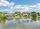 Scenic view of several homes overlooking a tranquil lake, perfect for peaceful living and enjoying nature's beauty at 8043 Pine Hollow Dr, Mount Dora, FL 32757