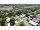 An aerial view of a residential neighborhood with well-maintained lawns and mature trees, with a golf course in the background at 860 Wolf Creek St, Clermont, FL 34711