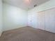 Bright bedroom boasting closet space, neutral carpet, and an overhead light at 860 Wolf Creek St, Clermont, FL 34711