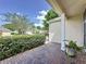 A brick porch offers views of a landscaped lawn with manicured shrubs and neighboring homes at 860 Wolf Creek St, Clermont, FL 34711